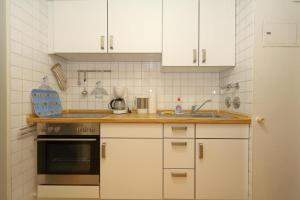 韦斯特兰Haus-am-Meer-App-71的厨房配有白色橱柜和炉灶烤箱。