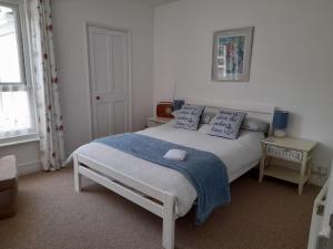 滨海戈尔斯顿'Pavilion Cottage' next to Gorleston beach with sea views - pet friendly!的一间卧室配有一张带蓝色毯子和枕头的床。