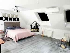 奥斯纳布吕克CITYLIFE Apartments Osnabrück mit E-Ladesäule的一间卧室配有一张带粉色毯子的床