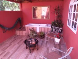 Belo ValePousada Princesa Do Vale的红色的客房设有浴缸和桌椅