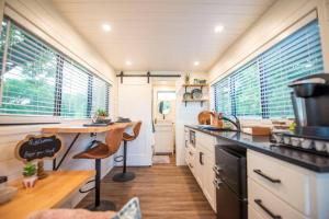 BellmeadNEW The Brazos-Tiny Home 12 Min to downtown的厨房配有柜台和一些窗户。