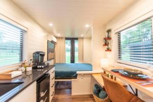 BellmeadNEW The Brazos-Tiny Home 12 Min to downtown的一个小房子里的一个小厨房,配有床