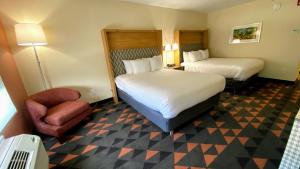 斯帕坦堡Holiday Inn Spartanburg Northwest的酒店客房,配有两张床和椅子
