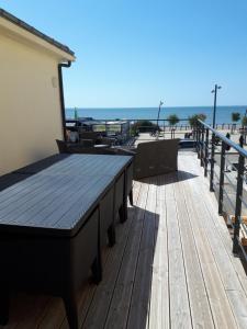 圣米歇尔-谢夫谢夫Maison et grande terrasse face mer的海滩上带桌椅的木制甲板