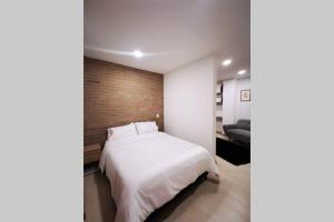 马尼萨莱斯Apartamento exclusivo en Manizales-Gran ubicación!的卧室配有白色的床和砖墙