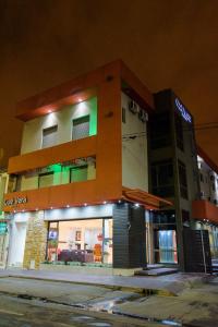 巴拉那Hotel Coé Verá的夜间在建筑物前的商店