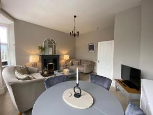 BirnamLovely Entire Flat in Birnam, neighbouring Dunkeld的客厅配有桌子和沙发
