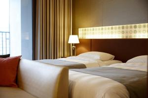 扶余扶余乐天度假酒店的酒店客房,设有两张床和一盏灯