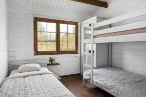 海斯勒霍尔姆Cozy Cottage near lake的一间卧室设有两张双层床和一扇窗户。