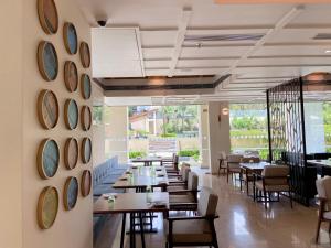 坎多林Holiday Inn Goa Candolim的一间墙上配有桌椅和时钟的餐厅