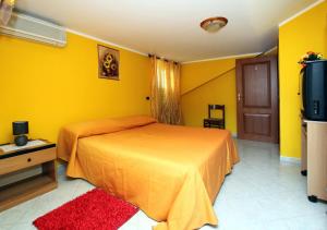 维博瓦伦蒂亚码头Bed and Breakfast Vibo Mare的一间卧室设有一张床和黄色的墙壁