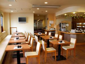 大洲欧塔酒店的一间带木桌椅的餐厅和一间厨房