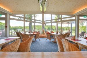 Freren萨勒海埃姆斯兰德酒店的用餐室设有桌椅和窗户。