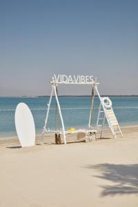 乌姆盖万乌姆盖万海滩葳达度假村 的海滩上的标志,海滩上设有冲浪板