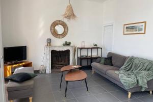 阿贡库坦维尔Agon-Coutainville, villa bord de mer的带沙发和壁炉的客厅