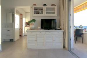 圣阿古斯丁Magical Sea View Accommodation Gran Canaria的一间客厅,客厅的白色橱柜上配有电视