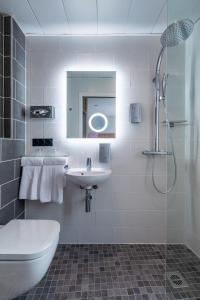 巴黎贝勒弗巴黎北车站酒店的白色的浴室设有水槽和淋浴。
