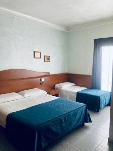 米兰奥罗拉酒店的酒店客房设有两张床和窗户。