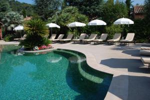 卡罗莱斯佩里多酒庄酒店的庭院内一个带椅子和遮阳伞的游泳池
