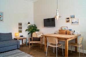 阿姆斯特丹阿姆斯特丹阿姆斯特尔住宿加早餐公寓的客厅设有餐桌和蓝色沙发