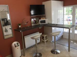 南莱潘Dépendance individuelle的厨房配有一张桌子、微波炉和凳子