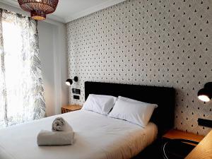 萨拉曼卡Hotel Matilde by gaiarooms的卧室里设有一张床,上面有一只动物