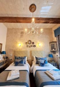 瓦莱塔Casa Asti的一间卧室配有两张床和吊灯。