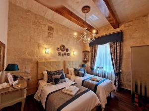 瓦莱塔Casa Asti的一间卧室设有两张床和石墙