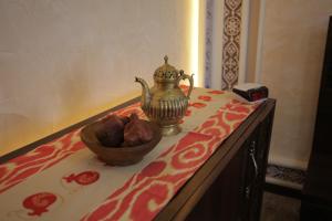 苦盏Sugdiyon Hotel的桌上的水果碗和茶壶