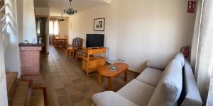 CanenciaSierra Norte的带沙发、桌子和电视的客厅