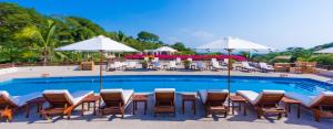 克鲁兹德华纳卡克斯特尔Grand Matlali Riviera Nayarit的一个带桌椅和遮阳伞的游泳池
