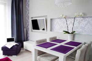 斯维诺乌伊希切Sunny Stay Apartment的一间设有白色桌子和紫色地毯的用餐室