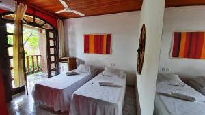 伊尔哈德博伊巴Pousada Ilha De Boipeba的一间设有两张床和一张桌子的房间