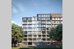 根特Schitterend nieuwbouw appartement in Gent的一座大型公寓楼,前面有树木
