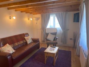 班特里Hillview Cottage的客厅配有棕色沙发和椅子
