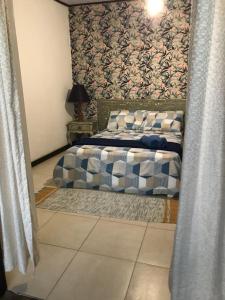 阿布拉奥Praia Comprida Flats的一间卧室配有一张带图案墙壁的床