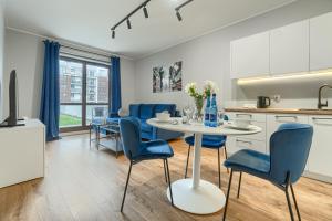 什切青EXCLUSIVE New Town Apartments的厨房以及带桌椅的用餐室。