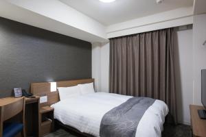 仙台仙台海滨通多米快捷酒店 的酒店客房设有床和窗户。