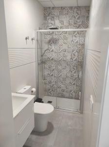 拜纳APARTAMENTO TURISTICO LYRA BAENA的白色的浴室设有卫生间和淋浴。