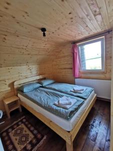 马里瑟尔Cabana Orizont Marisel的小木屋内一间卧室,配有一张床