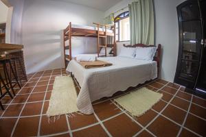 乌巴图巴Aldeia Ubatuba的卧室配有双层床,铺有瓷砖地板。