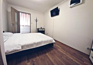 布拉索夫Camere in regim hotelier的卧室设有一张白色大床和一扇窗户。