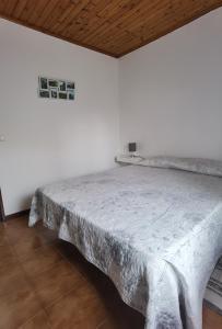 Faja GrandeCasa da Sogra - Apartamento 1的白色墙壁间的一张床位