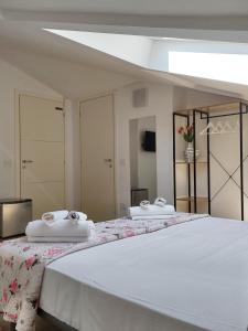 贝加莫贝尔加莫和丁多尼酒店的一张大床,上面有两条白色毛巾