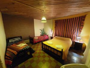 蒂诺加斯塔Munay EcoHostal - Cabañas de Adobe的一间卧室配有两张床和椅子