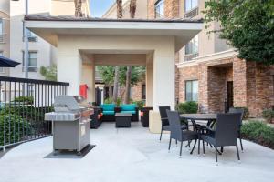 格伦代尔Staybridge Suites Phoenix Glendale Sports Dist, an IHG Hotel的一个带桌椅和烧烤架的庭院