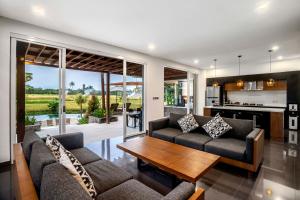 乌布Coconut Grove Villa by BaliSuperHost的客厅配有两张沙发和一张桌子