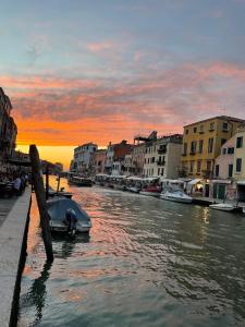 威尼斯Ca' Bonfadini Historic Experience的日落时分,船停靠在运河上