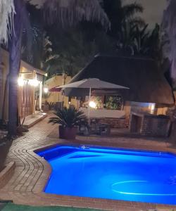 伊登维尔三兄弟住宿加早餐酒店的夜晚在院子里的一个蓝色游泳池