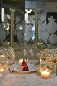 朱尼耶丽晶宫殿酒店的一张桌子,上面放着一盘食物,玻璃杯和蜡烛